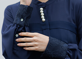 レース袖と貝ボタンのさりげないアクセント